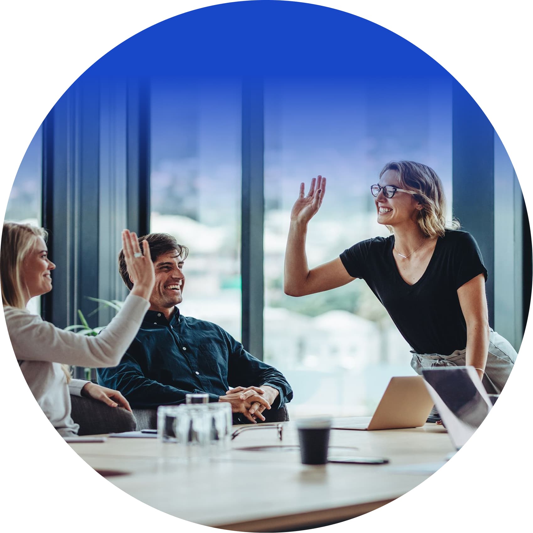 Diverse team high-fiving during a successful group learning session in a bright office.